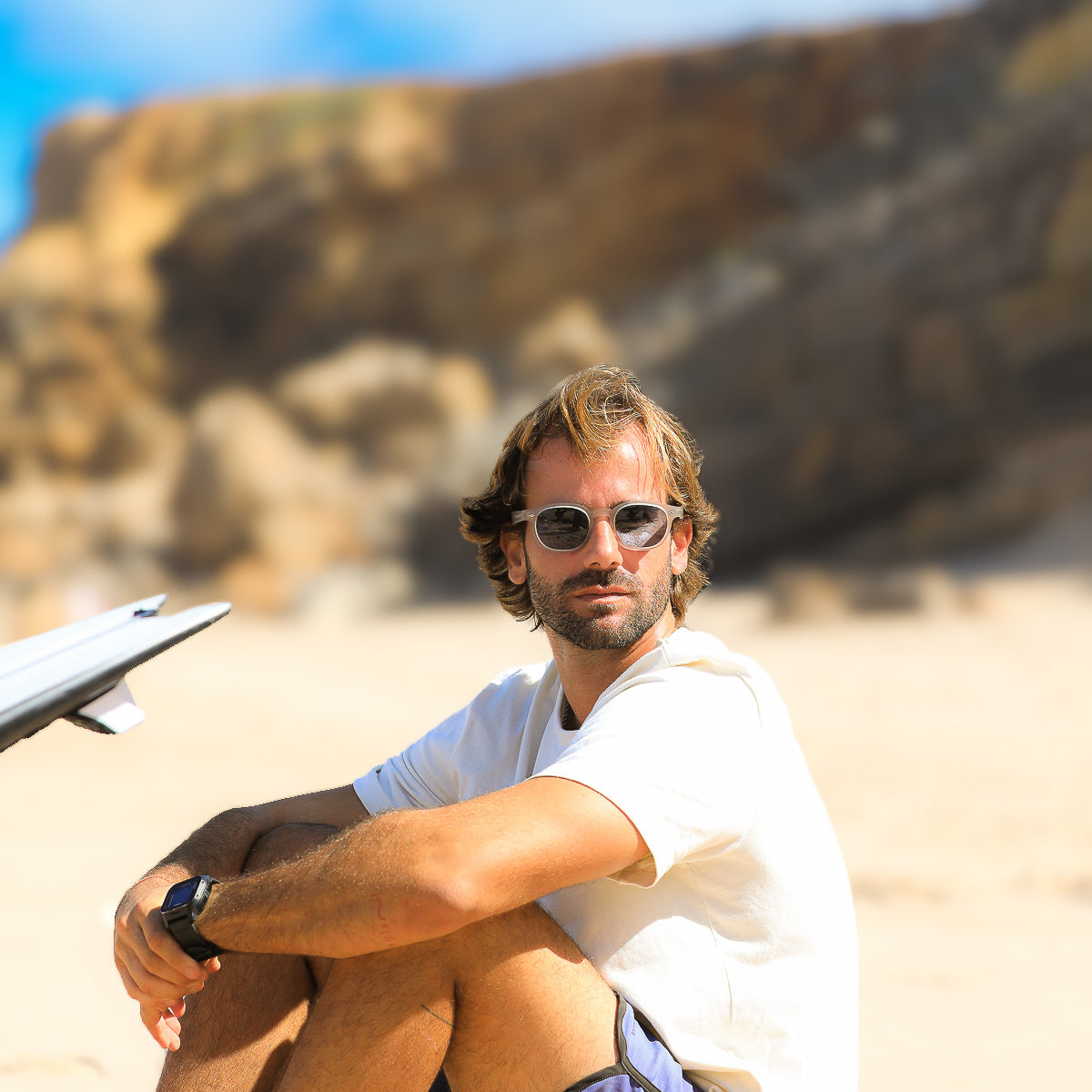 Mireye Fire sunglasses in Fog, worn outdoors on the beach under natural sunlight.
